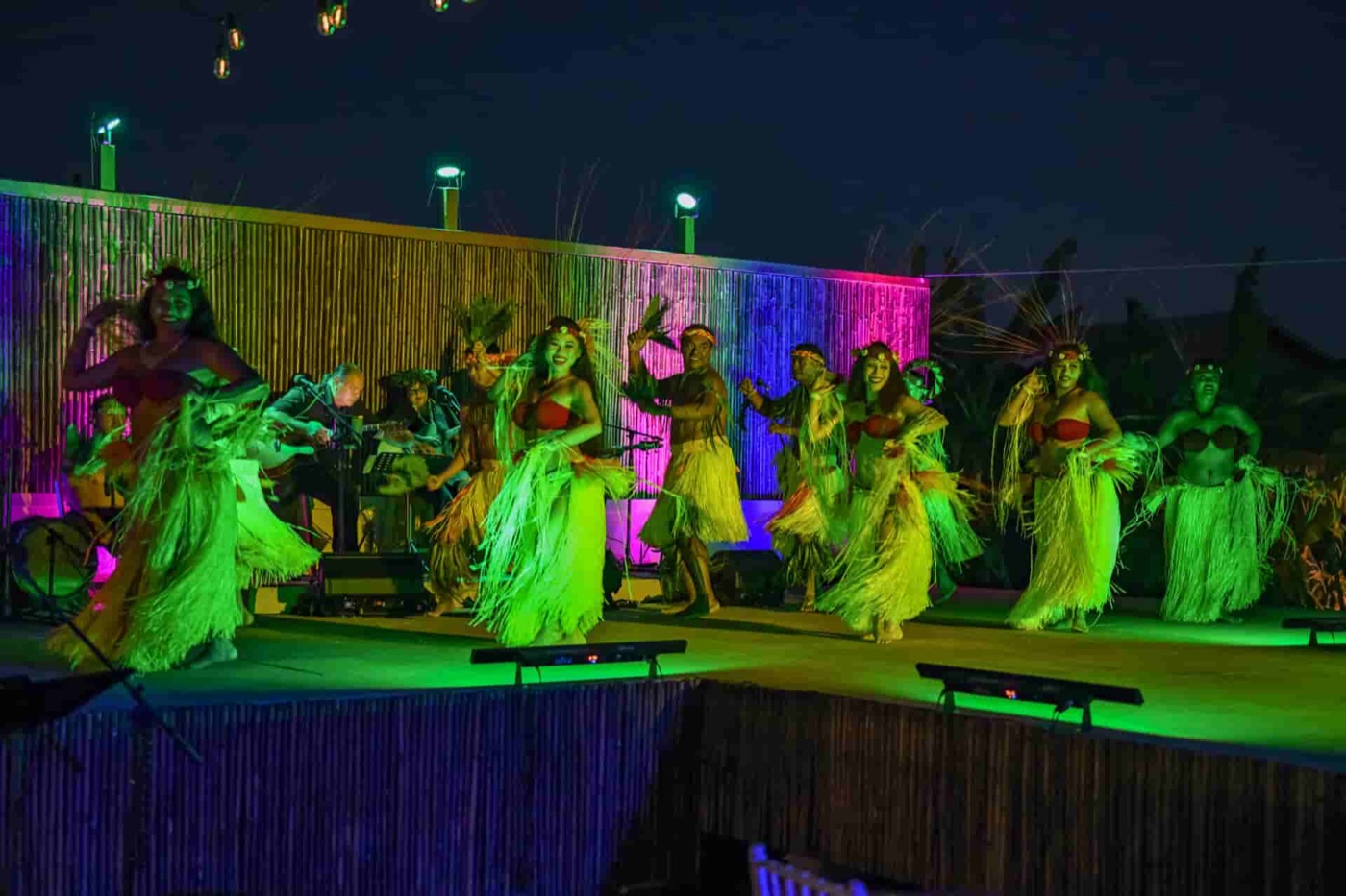 A company ensemble performs onstage under colored lights
