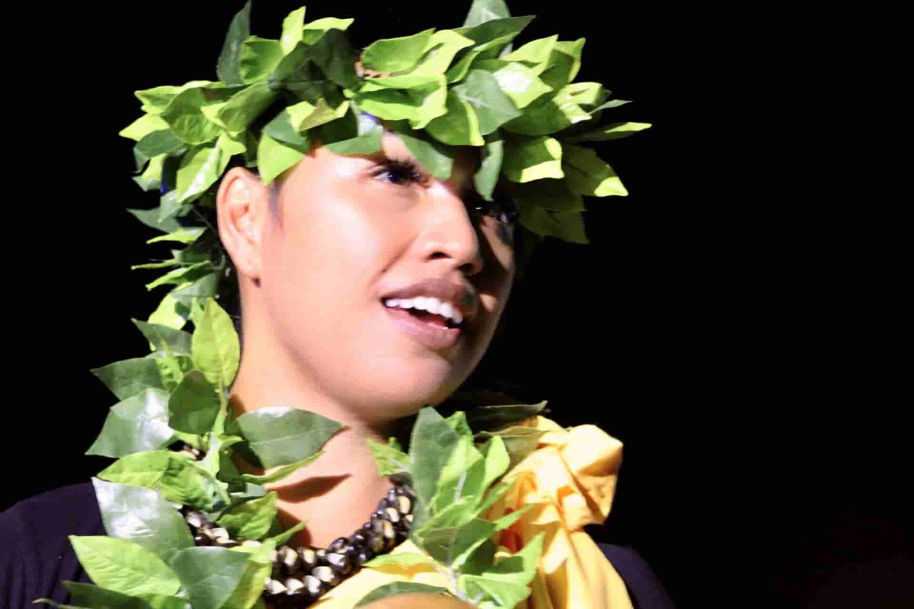 Close-up of a performer wearing a green leaf lei