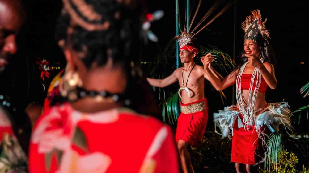 Two dancers in red costumes performing at night