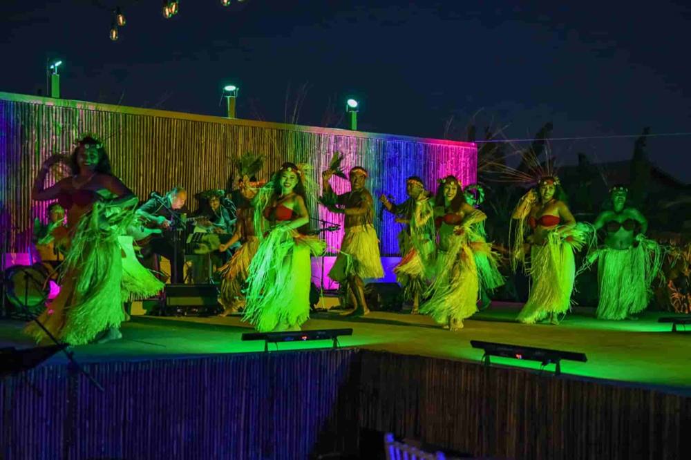 Full lūʻau revue on stage with dancers and musicians