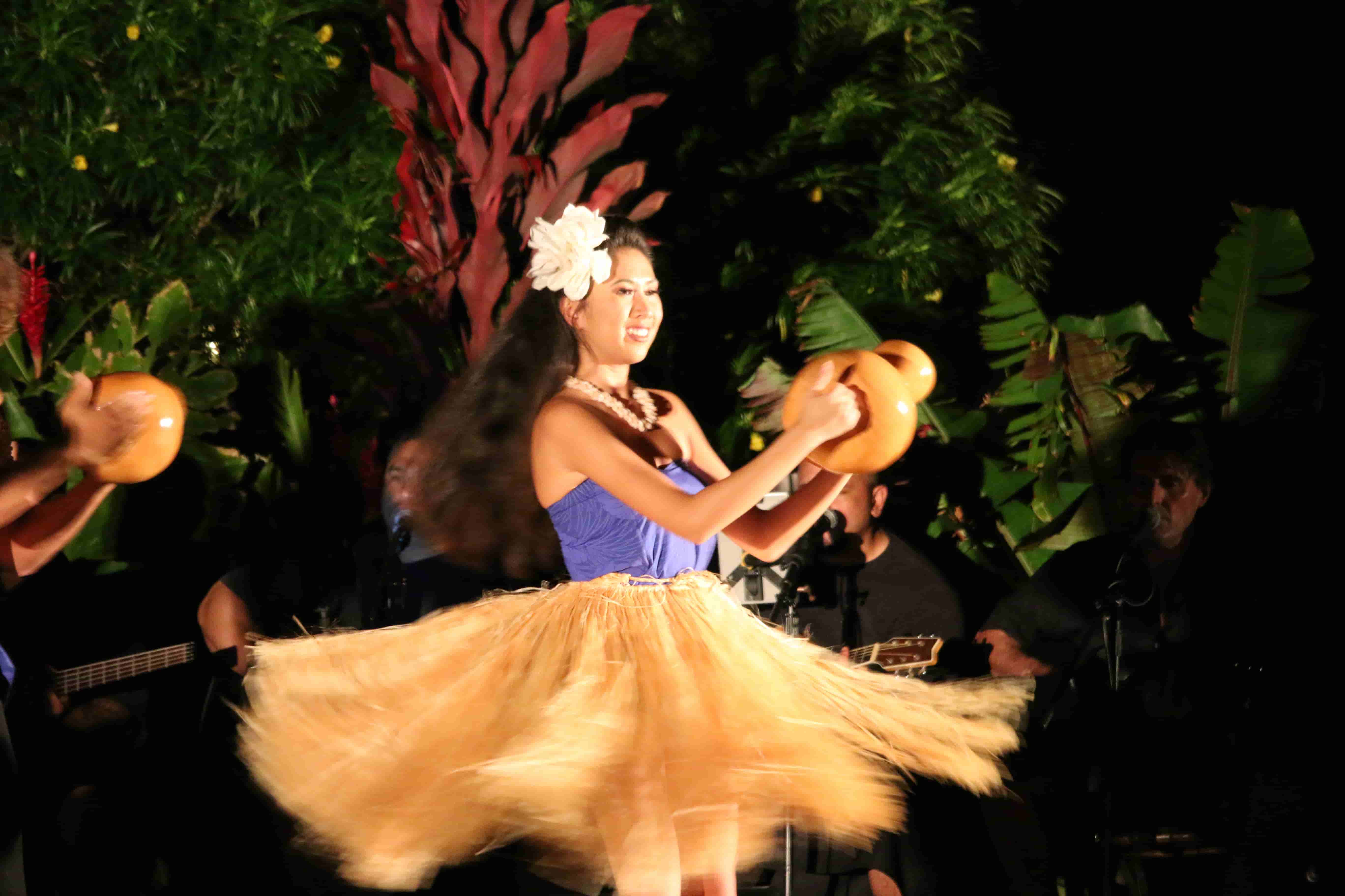 Hula dancer spinning with ipu gourd at outdoor performance